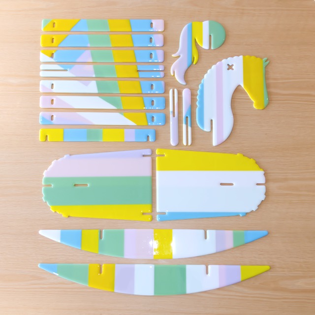 Flat-lay of the nine unassembled glass panels that make up the rocking horse